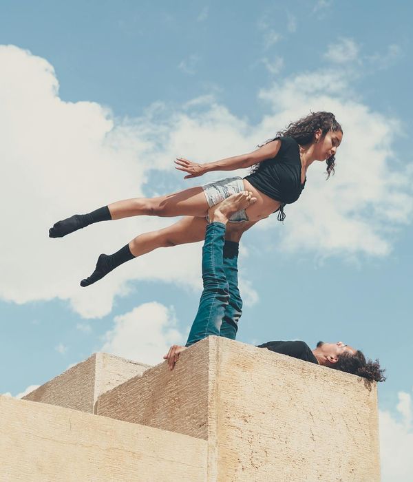Man performing a controlled bodyweight exercise in a dark, minimalist setting.